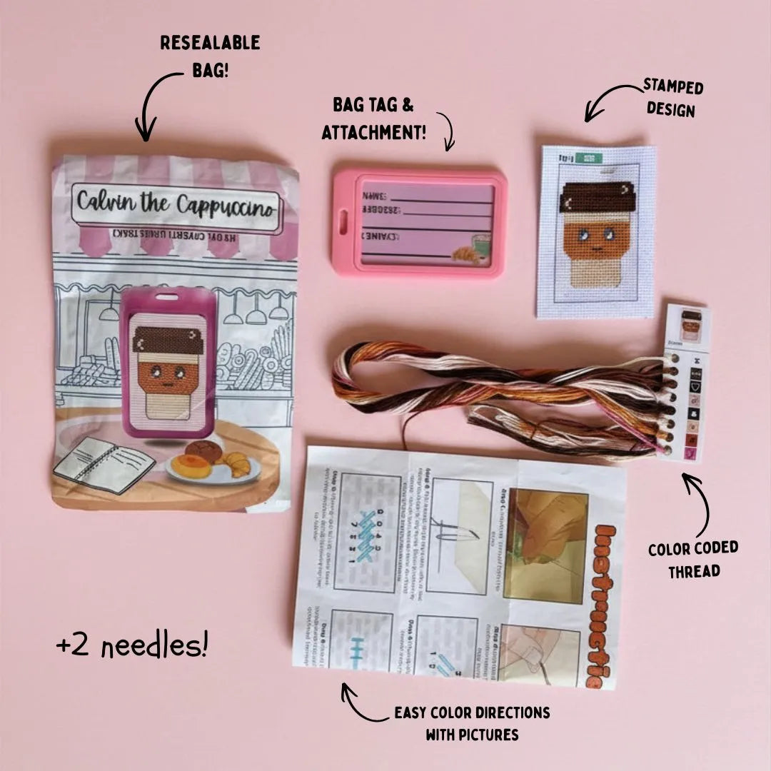 Calvin the Cappuccino embroidery kit with resealable bag, bag tag, attachment, stamped design, color-coded thread, needles, and easy color directions on a pink background.