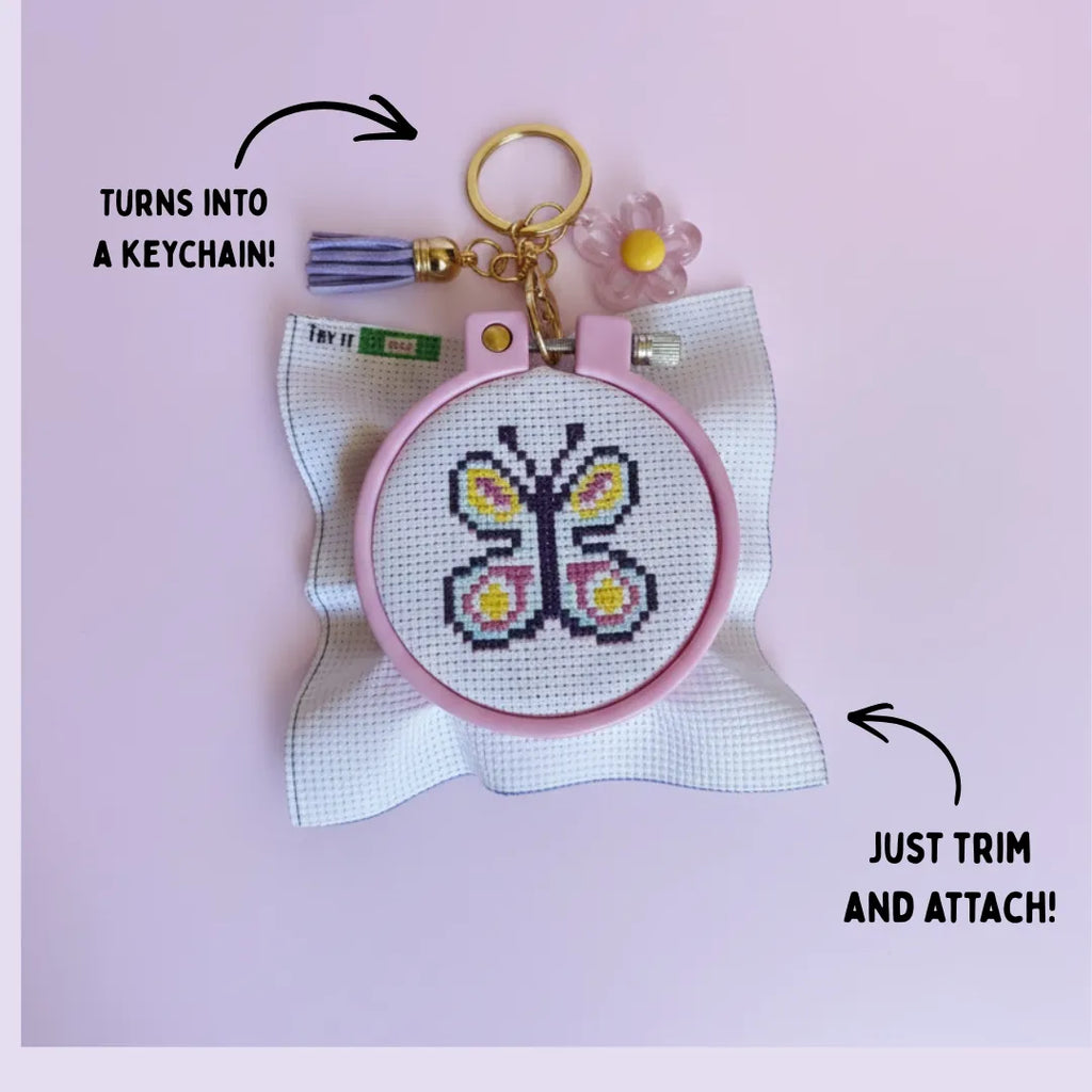 Beatrice the Butterfly completed cross stitch keychain in pink embroidery hoop