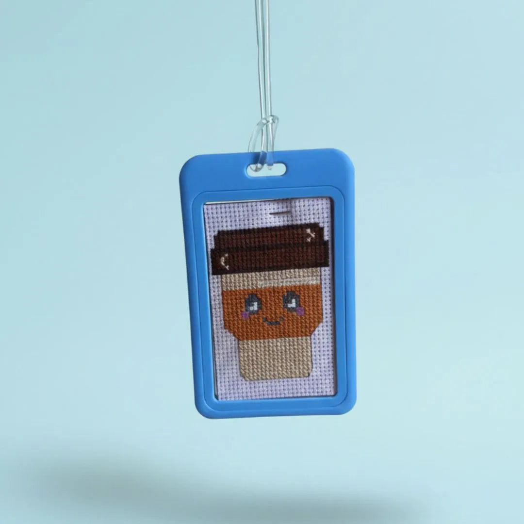 Cross-stitched character in a blue frame on a light blue background