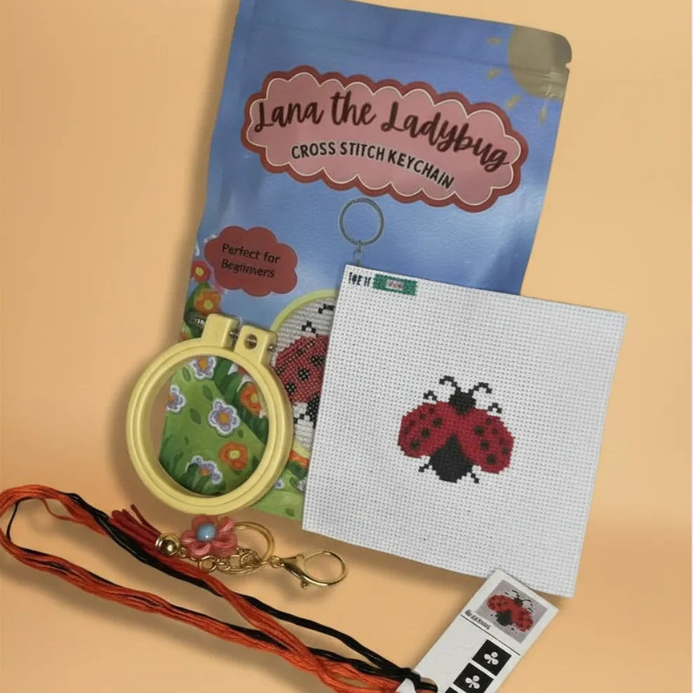Cross stitch keychain kit with ladybug design on a beige background