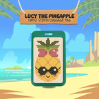 Cross-stitch pineapple luggage tag with sunglasses and a bow, set against a tropical beach background.